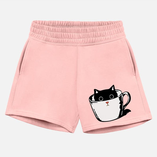 Black kitten with red nose hiding in a cup